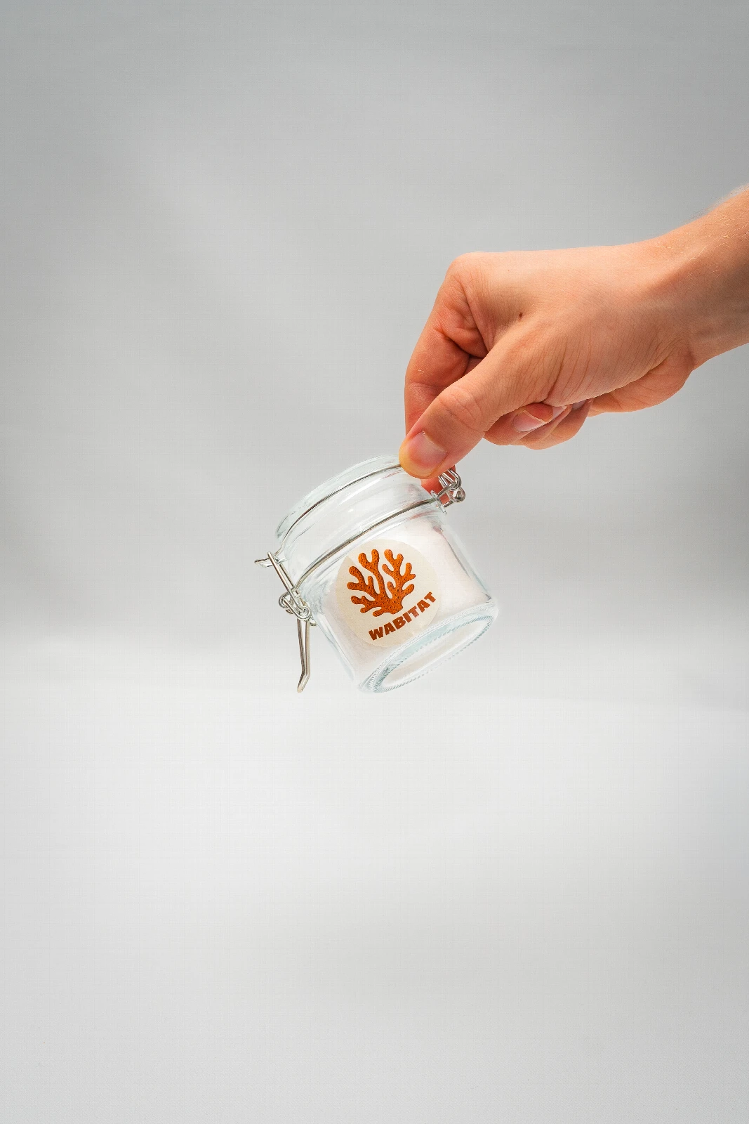 A reusable mesh produce bag, a steel bottle and cotton napkins on a wooden table